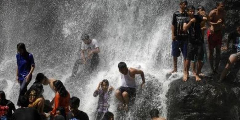 Pengunjung menikmati deburan Air Terjun Sindulang atau Curug Cinulang di Kampung Sindangwangi, Desa Tanjungwangi, Kecamatan Cicalengka, Kabupaten Bandung, Jawa Barat, Sabtu (25/8/2014).  